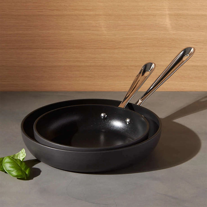 Two sets of All-Clad HA1 hard anodized nonstick 8 inch and 10 inch fry pans shown together on a kitchen surface